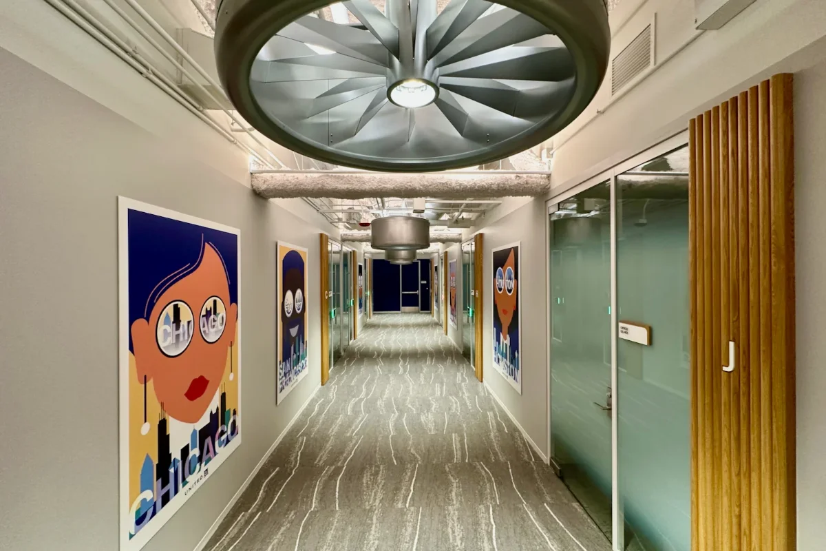 لوسترهای سالن شرکت هواپیمایی به شکل چرخ‌های هواپیما با دیوارهای کرمی و کف‌پوش قهوه‌ای-طوسی