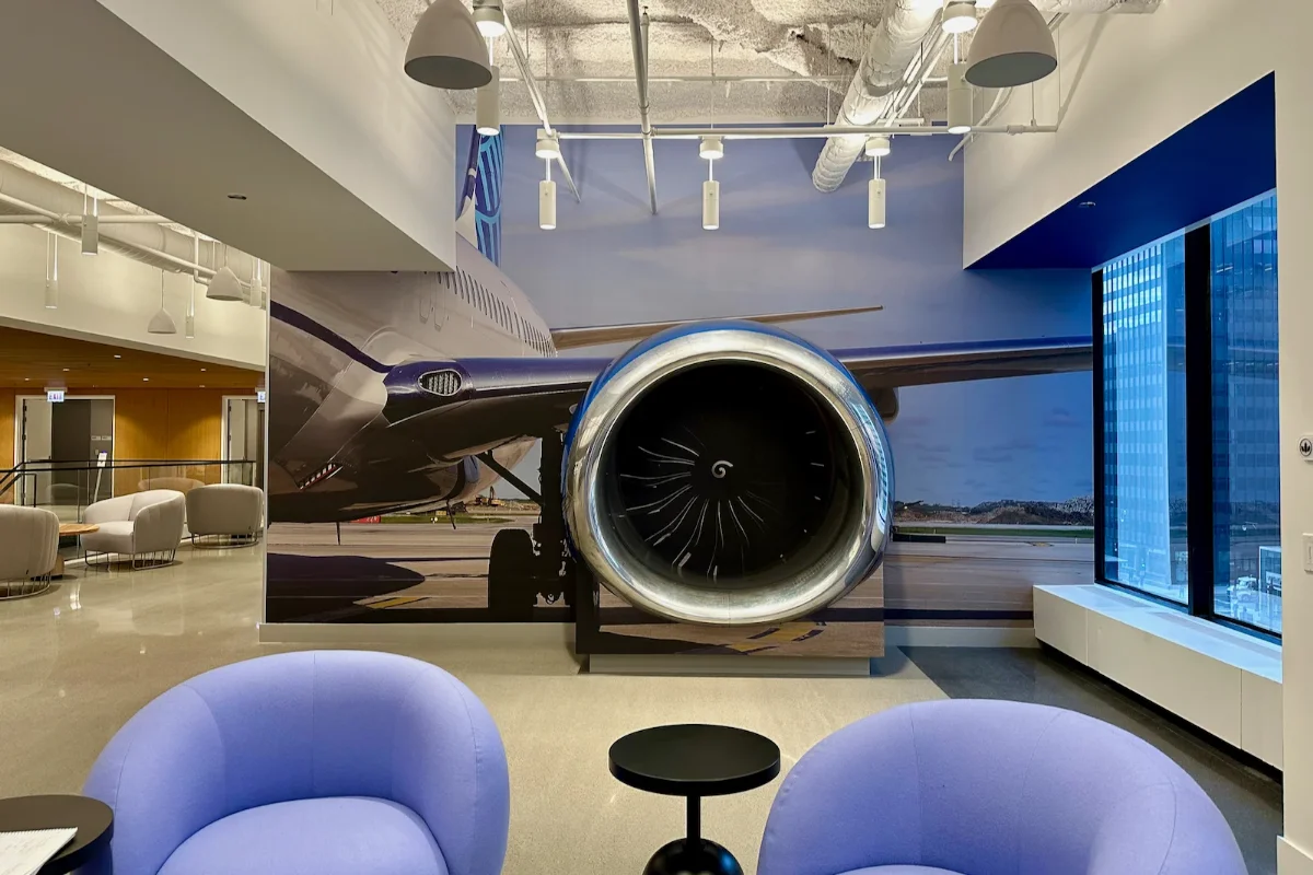 نصب هواپیما با موتور طوسی و بال‌های آبی روی دیوار شرکت هواپیمایی با پوستر عکس هواپیما