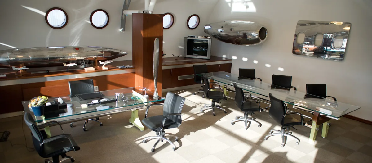 اتاق مدیریت شرکت هواپیمایی با پنجره‌های دایره‌ای شبیه به پنجره هواپیما