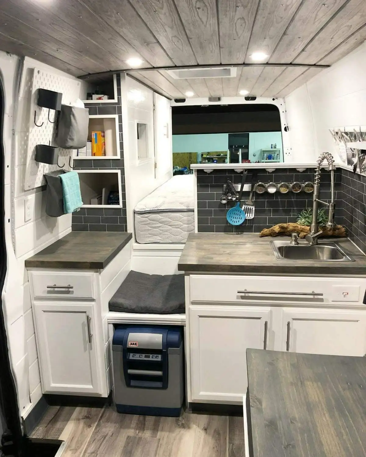 کابینت آشپزخانه کمپر به رنگ سفید همراه با یخچال کوچک