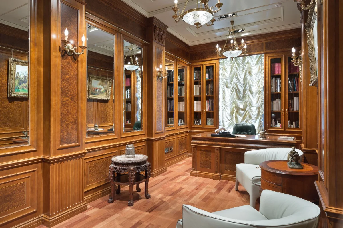 دکوراسیون اتاق‌کار چوبی قهوه‌ای با آینه‌های دیواری و کف‌پوش چوبی و مبلمان طوسی روشن