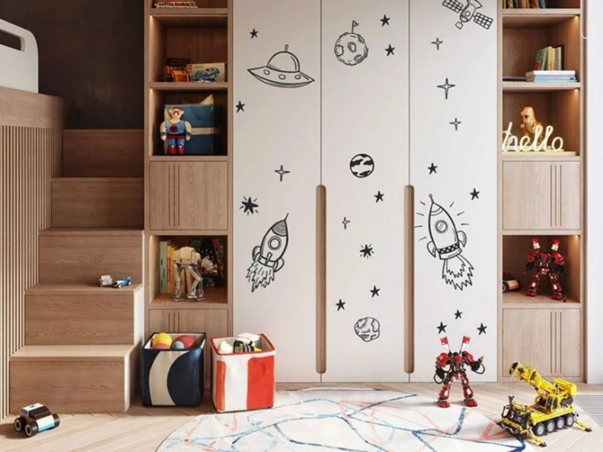 کمد دیواری نوزاد با درب سفید چوبی و دستگیره توکار به طراحی روی دربها به شکل سفینه و موشک