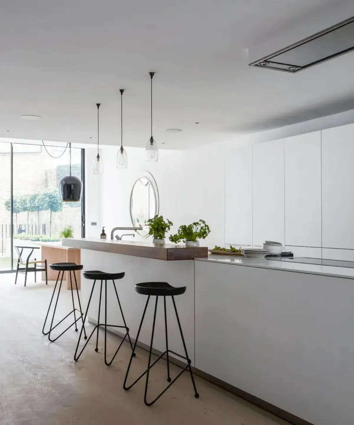 آشپزخانه با کابینت‌های سفید و صندلی فلزی مشکی