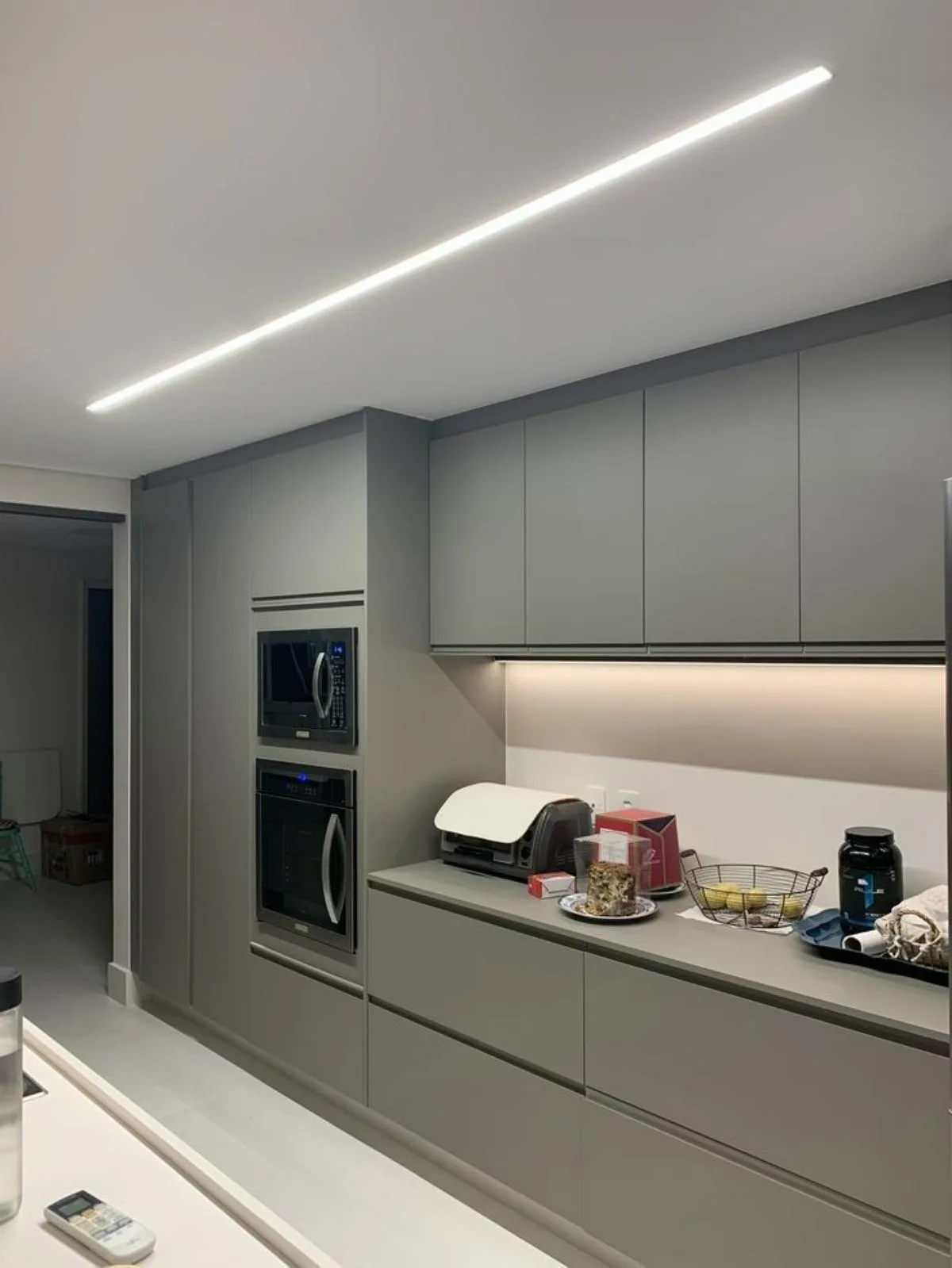 نورپردازی خطی سفید سقف آشپزخانه مدرن با کابینت‌های طوسی