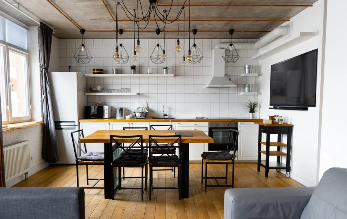 آشپزخانه با کابینت مدرن سفید با چراغ‌های آویز مشکی