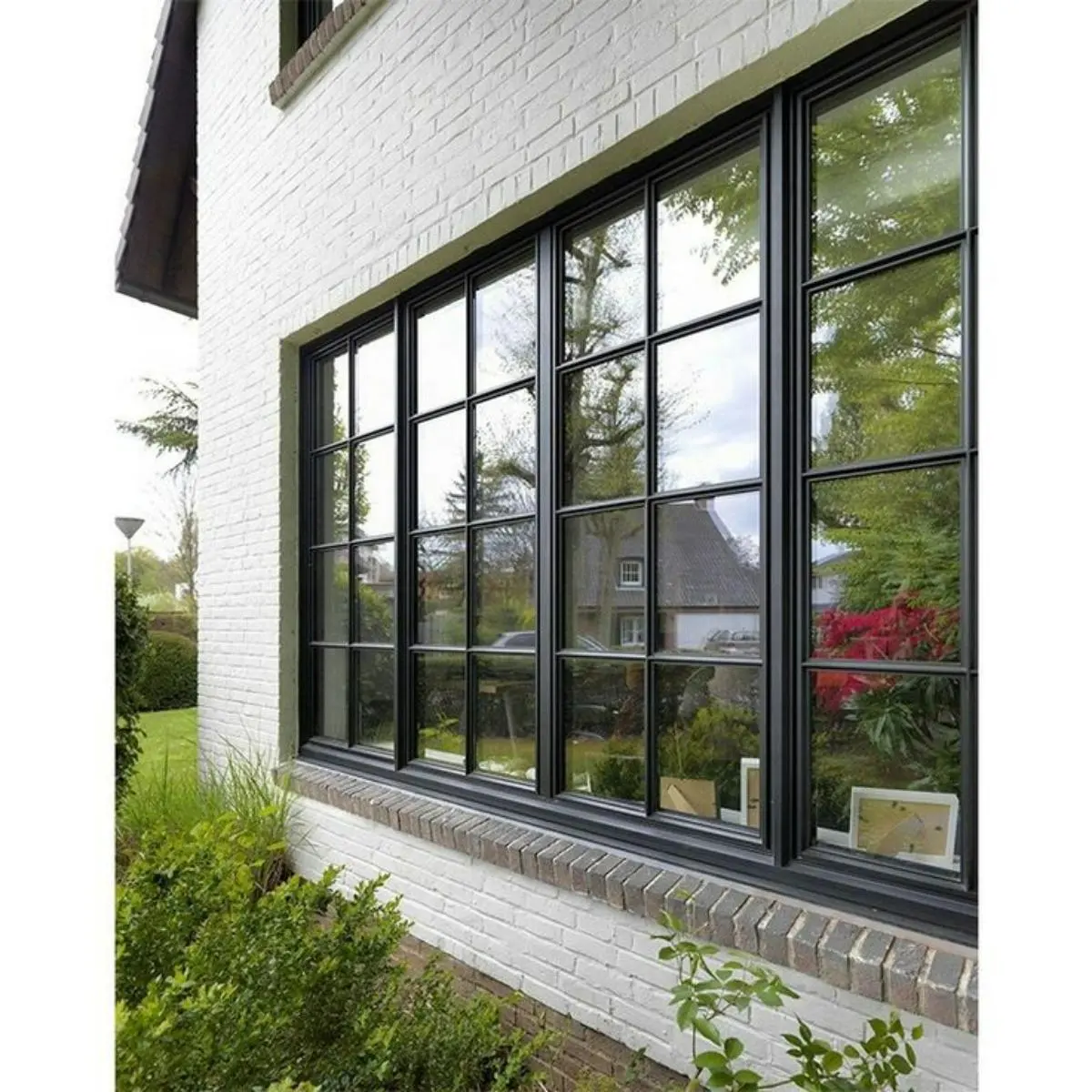 پنجره دو جداره مشکی در ترکیب با دیوارهای آجری سفید بیرون از خانه