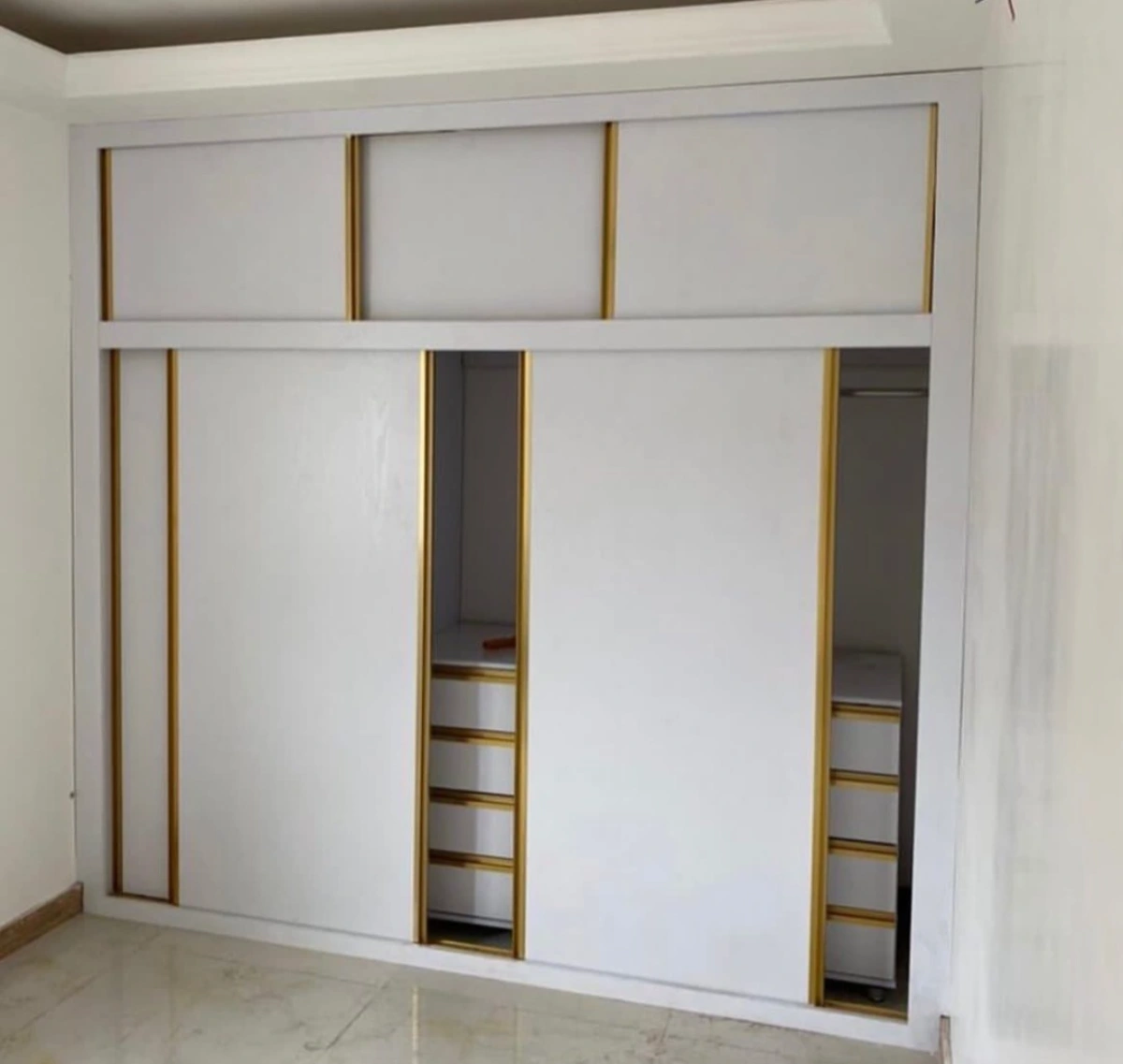 نمونه اجرا شده از کمد با درب ریلی رنگ سفید در ترکیب با طلایی برای اتاق کوچک