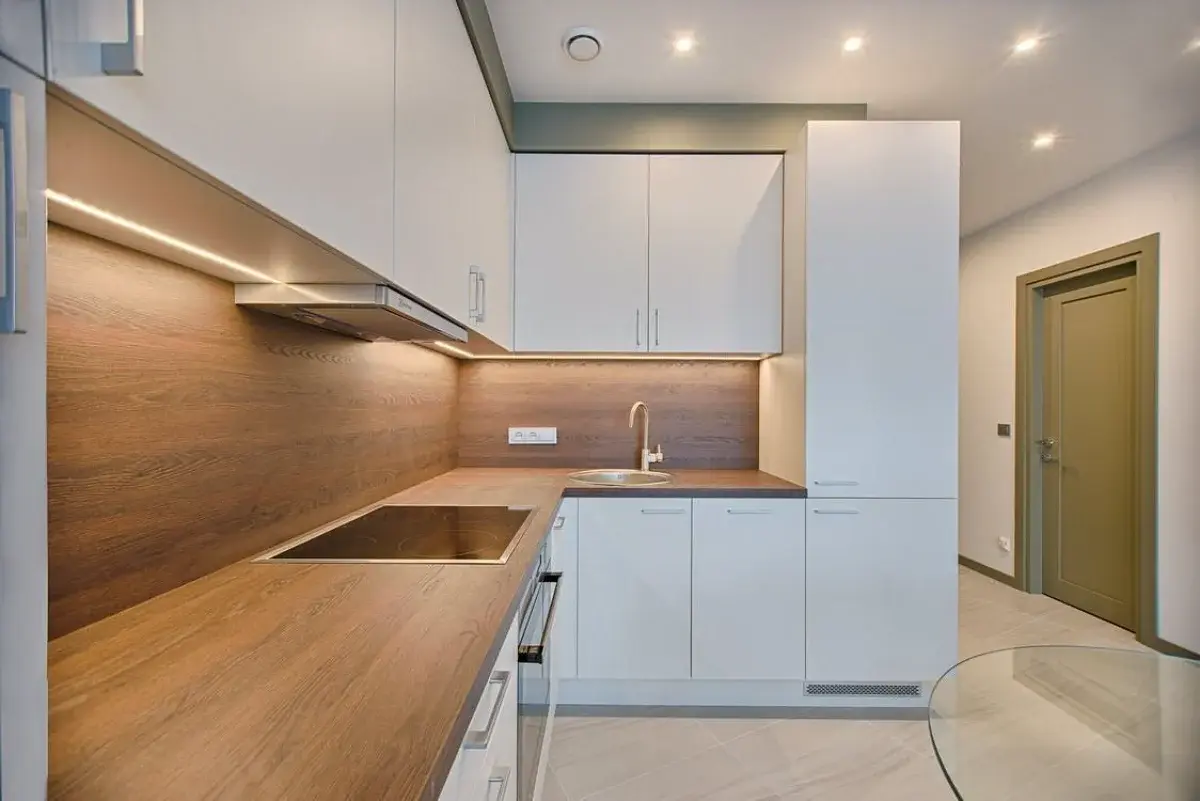 آشپزخانه مینیمال با کابینت‌های سفید و قهوه‌ای و بدون شلوغی