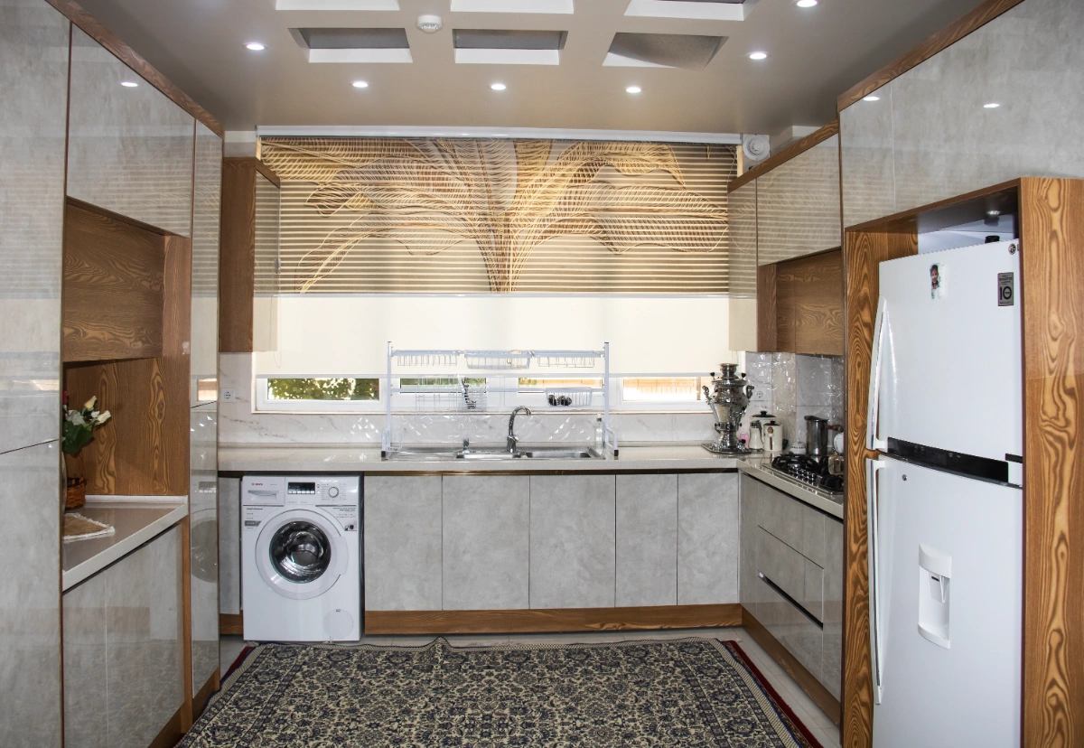 کابینت پلی گلاس مدرن به رنگ سفید و چوبی بصورت یو شکل در آشپزخانه پنجره دار